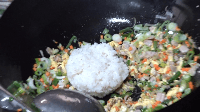 White rice poured over stir-fried vegetables and meat