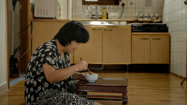 Elderly woman having a meal alone in a kitchen