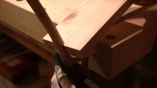 Hands assembling wooden pieces in workshop