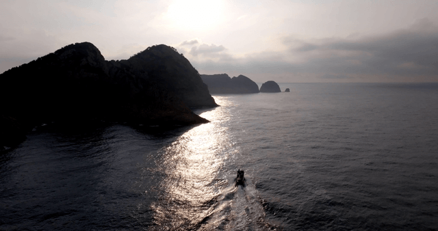 A boat sailing near rocky islands