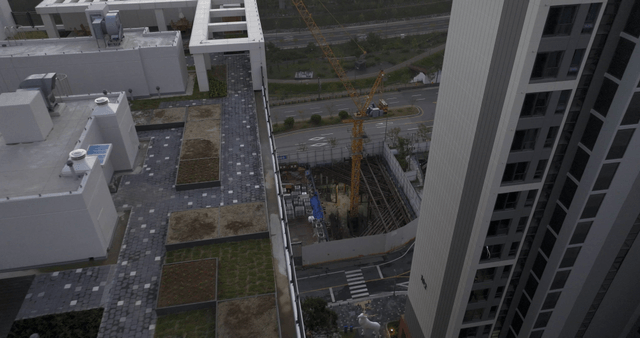 High-rise buildings with rooftop gardens and construction site