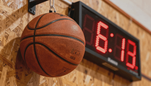 Basketball hanging near a digital scoreboard