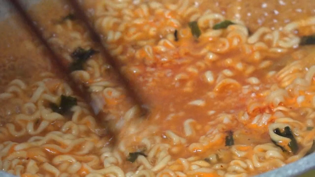 냄비에서 매운 라면을 젓는 젓가락