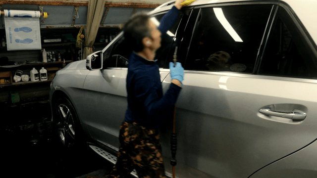 Worker cleaning a car in a garage