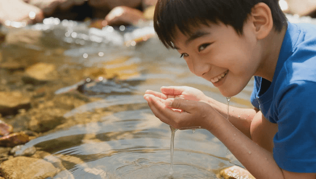 A child playing by a clear stream