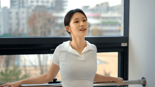 Young woman smiling while stretching by the window