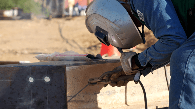 야외에서 금속을 용접하는 작업자