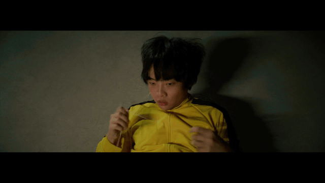 Person in a yellow tracksuit lying on the floor