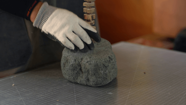 Person working with a stone indoors