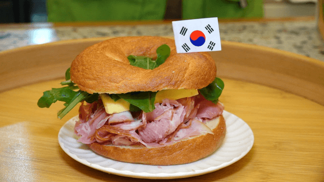 A sandwich with ham and greens on a plate