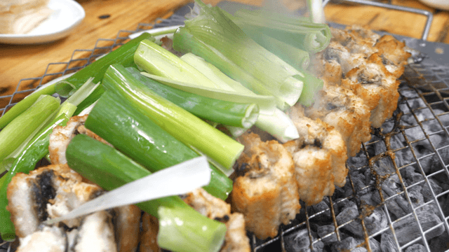 Green onions placed over charcoal-grilled eels