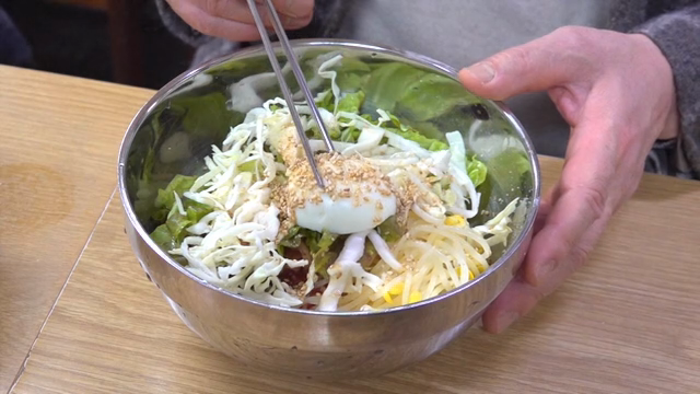 Egg on top of spicy chewy noodles with lots of vegetables