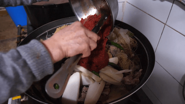 한국식 고깃국에 매운 양념을 넣는 장면