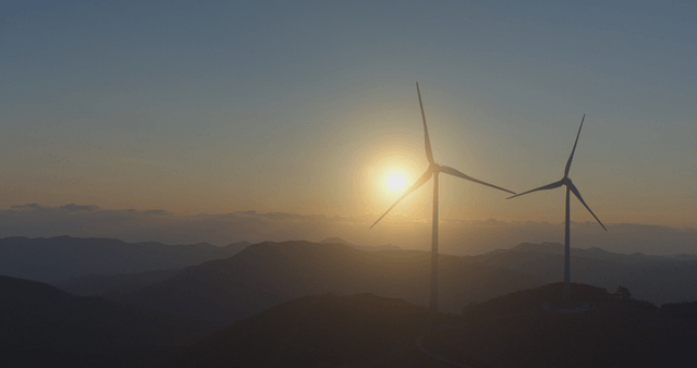 돌아가는 풍력 터빈 옆 일출