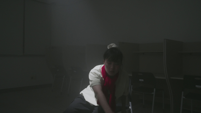 Girl dancing spontaneously in a dark reading room