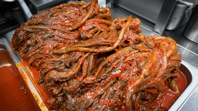 Tray filled with red gatgimchi in kitchen