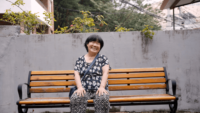 Elderly woman smiling on a bench