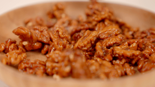 Caramelized walnuts in a wooden bowl