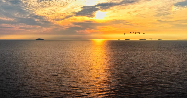 Sunset over a calm ocean with islands
