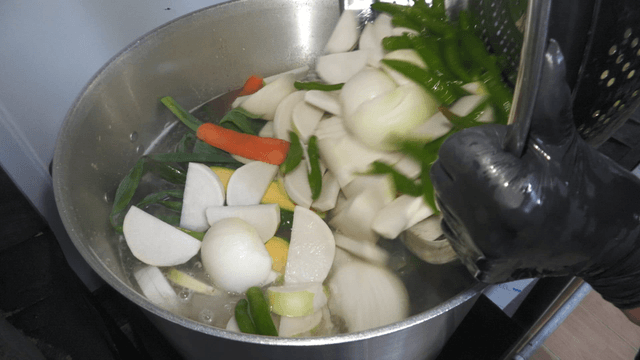 Vegetables added into a boiling pot