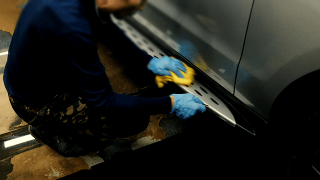 Worker cleaning a car with a cloth