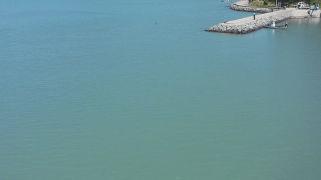 Calm sea with a boat and distant mountains
