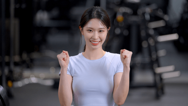 Young woman cheering with clenched fists at gym