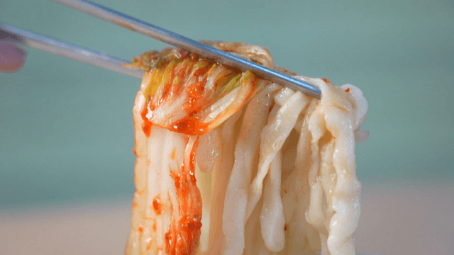 Kimchi lifted with chopsticks and hand-cut noodles