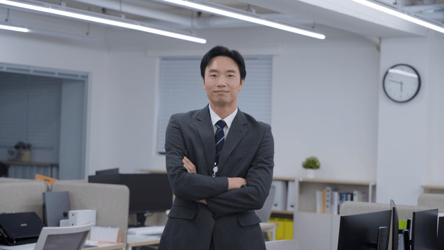 사무실에서 팔짱 끼며 미소 짓는 직장인