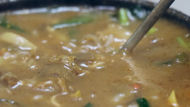 Sundae soup in a hot pot stirred with a spoon
