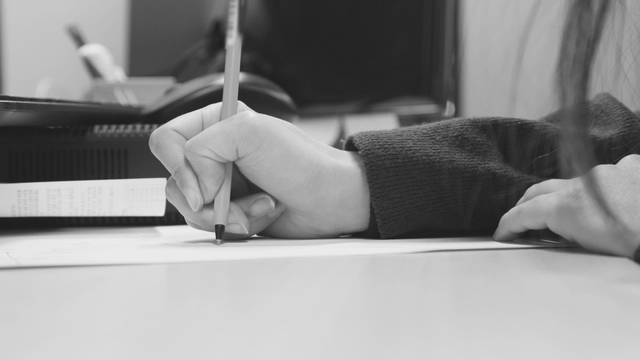 Person writing notes at a desk