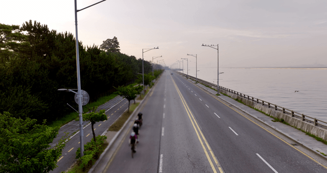 Cyclists riding along a coastal road