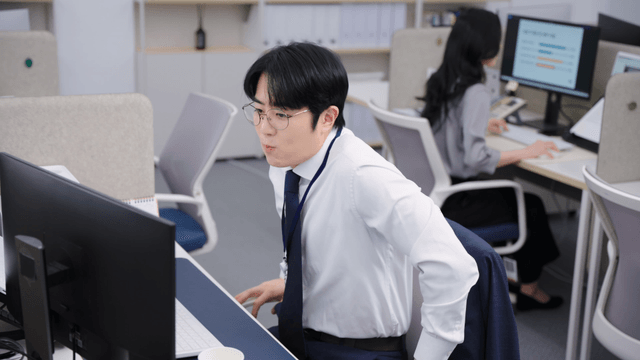 책상에서 물을 마시는 사무직원