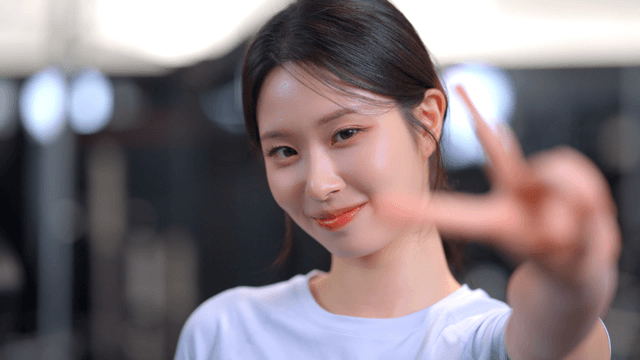 Young woman smiling and making a finger V sign