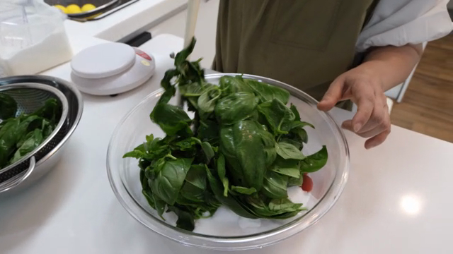 Mixing fresh basil leaves in a kitchen