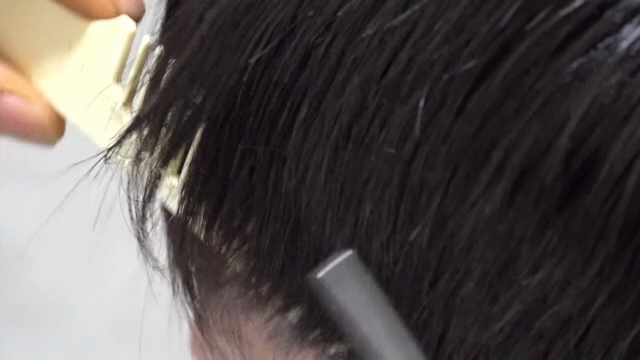 Hair being trimmed with scissors and comb