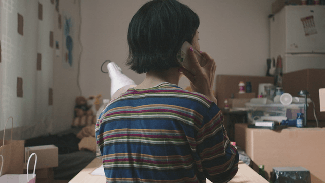 Person talking on the phone in a cluttered room