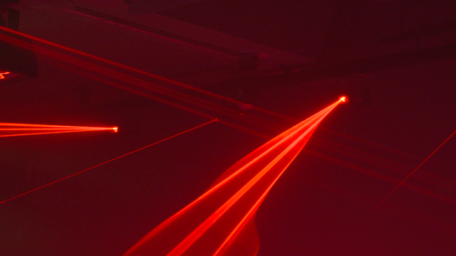 Vivid red laser beams on dark stage