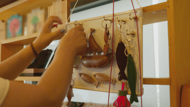 Hands arranging handcrafted leather keychains