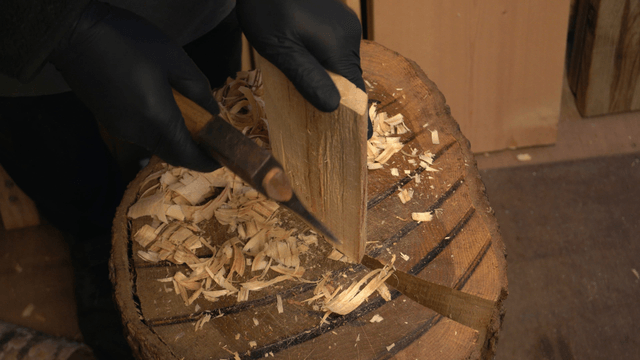 Artisan carving wood with a hand axe