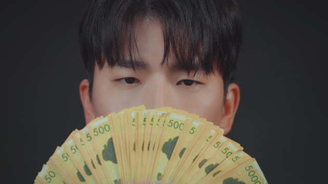 Person holding a fan of currency notes