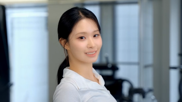 Young woman smiling back while adjusting tied hair