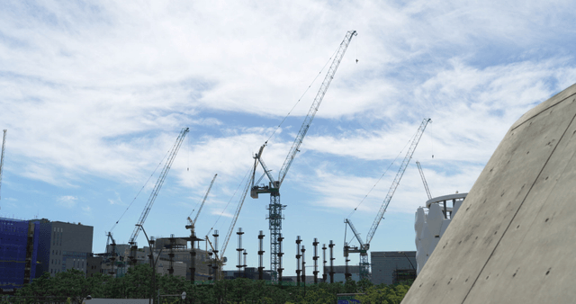 Construction cranes in the city under a clear sky