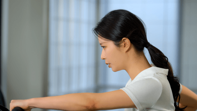 Young woman exercising at gym on a machine