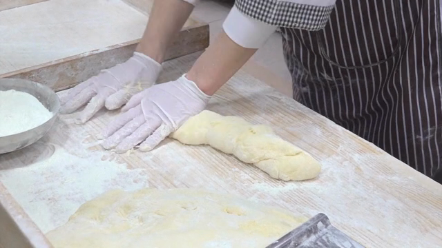 Baker kneading dough on a floured surface