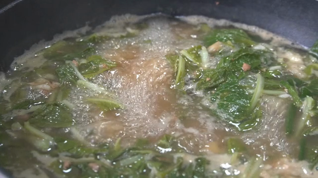 Soybean paste soup with greens boiling in a pot