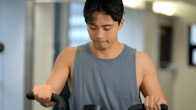 Young man exercising at gym on a machine