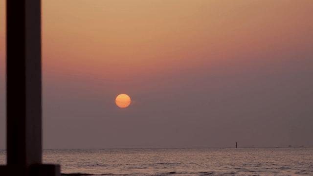 Sunset over the calm ocean horizon