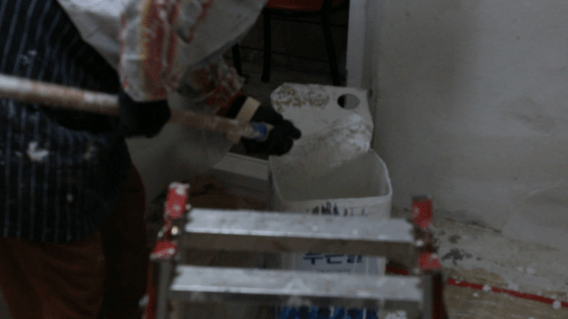 Person dipping a roller in paint