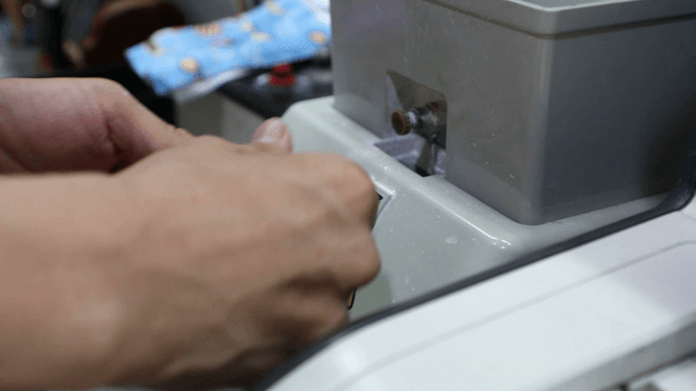 Person operating a lens grinding machine